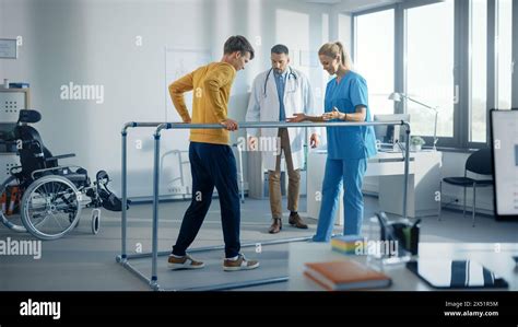 Hospital Physical Therapy Strong Patient With Back Injury Making First Slow Steps Walks Holding For Parallel Bars Physiotherapist Rehabilitation Doctor Assist Help Encourage Disabled Person Stock Photo Alamy