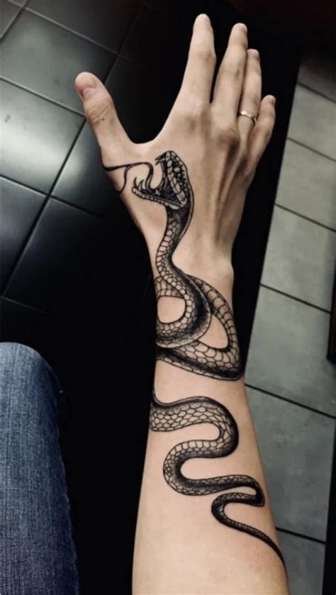 This Tattoo Tells A Story Of Survival And Strength The Snake Biting The Hand Symbolizes The Battles We Face In Life Moments Of Pain Challenge And Resilience But With Every Bite Comes Wisdom This Tattoo Tells A Story Of Survival And Strength The Snake Biting The Hand Symbolizes The Battles We Face In Life Moments Of Pain Challenge And Resilience But With Every Bite Comes Wisdom